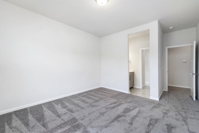 unfurnished bedroom with light carpet and ensuite bath