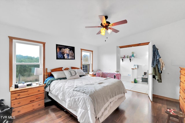 bedroom featuring ceiling fan, ensuite bathroom, and dark hardwood / wood-style flooring