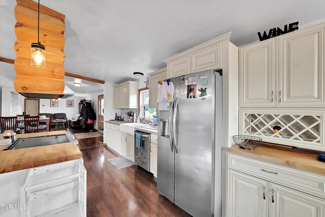 kitchen with decorative light fixtures, stainless steel appliances, dark hardwood / wood-style flooring, sink, and wood counters