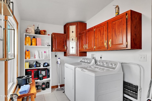 laundry room with cabinets, light tile patterned floors, and washing machine and clothes dryer