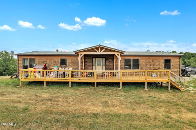 back of property with a wooden deck and a lawn