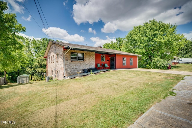 view of front facade with a front yard and a storage shed