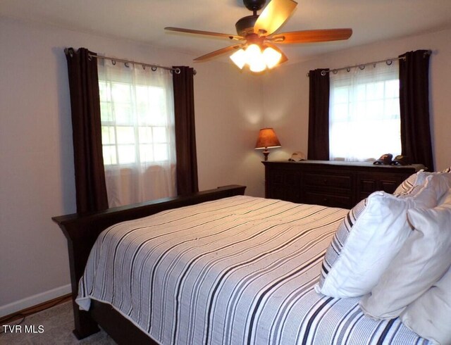 bedroom with carpet floors, multiple windows, and ceiling fan