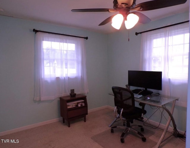 carpeted office space with plenty of natural light and ceiling fan