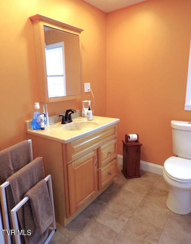 bathroom featuring vanity, tile patterned flooring, and toilet