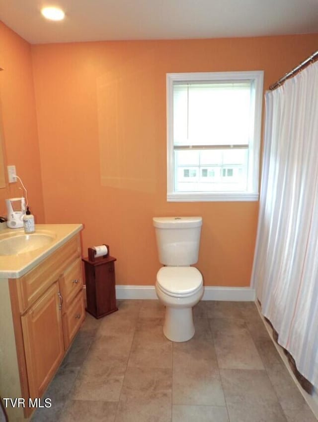 bathroom featuring tile patterned floors, vanity, toilet, and a wealth of natural light