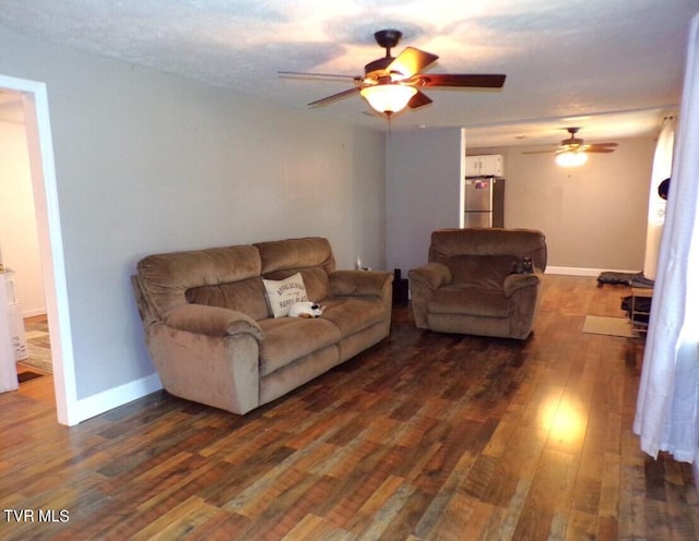 living room featuring dark wood-type flooring and ceiling fan