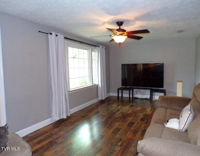 living room featuring ceiling fan and dark wood-type flooring