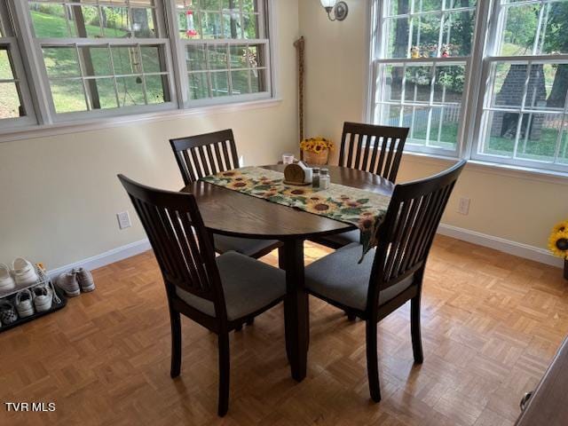 dining space featuring parquet flooring