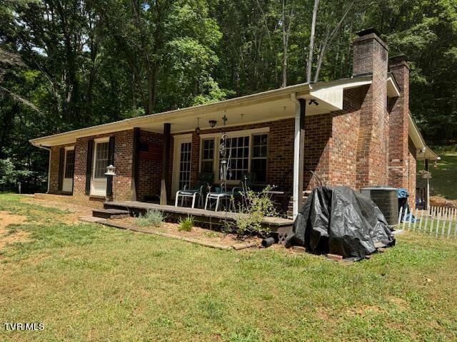 rear view of property with a yard