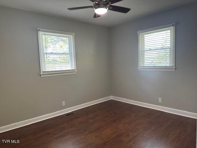 unfurnished room with ceiling fan and dark wood-type flooring