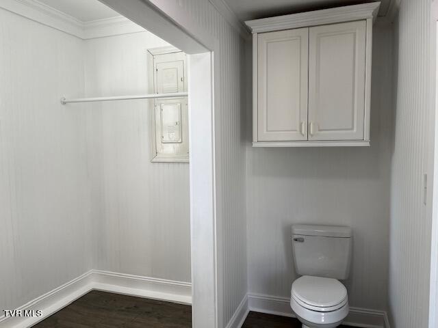 bathroom featuring wood-type flooring, crown molding, and toilet