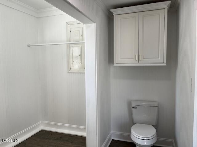 bathroom with wood finished floors, toilet, baseboards, and ornamental molding