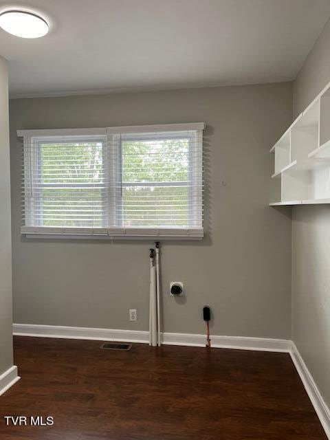 washroom with baseboards, dark wood-style flooring, visible vents, and laundry area