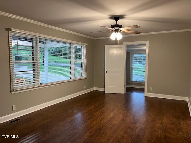 unfurnished room featuring plenty of natural light, baseboards, and wood finished floors