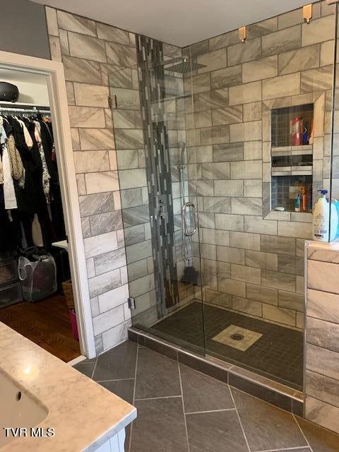 bathroom with walk in shower and tile patterned flooring