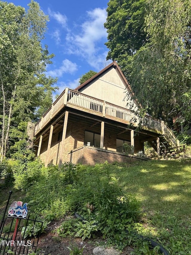 view of side of property featuring a deck and a lawn