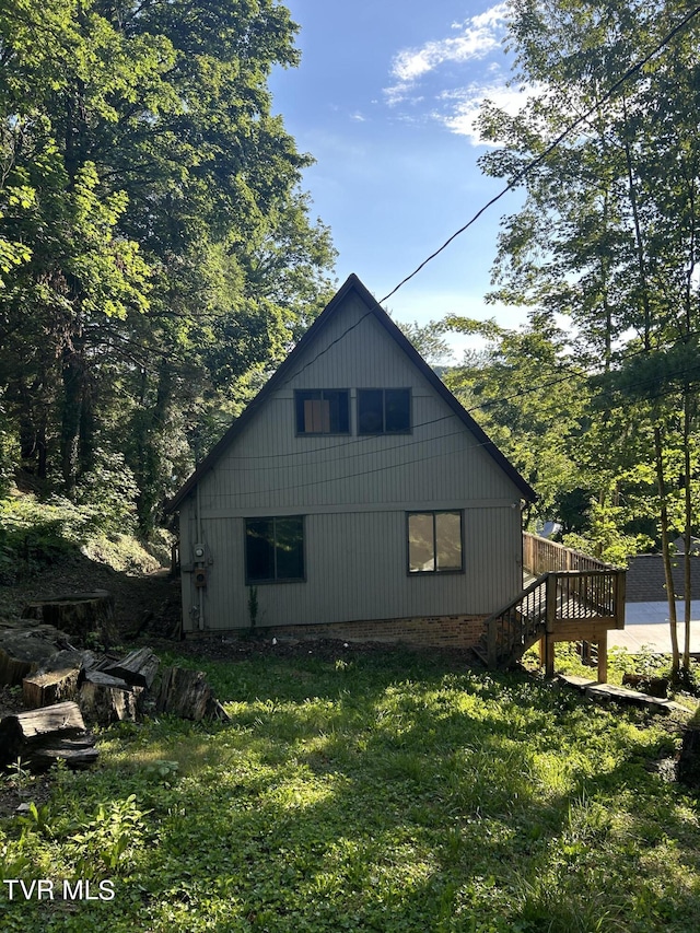 view of side of home with a lawn and a deck