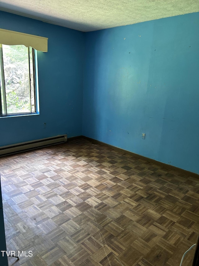 unfurnished room with dark parquet flooring, a textured ceiling, and a baseboard radiator