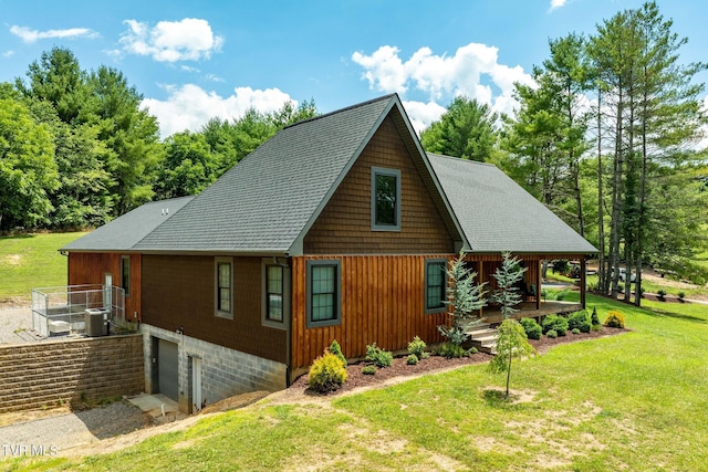 view of home's exterior with a garage, a yard, and central AC