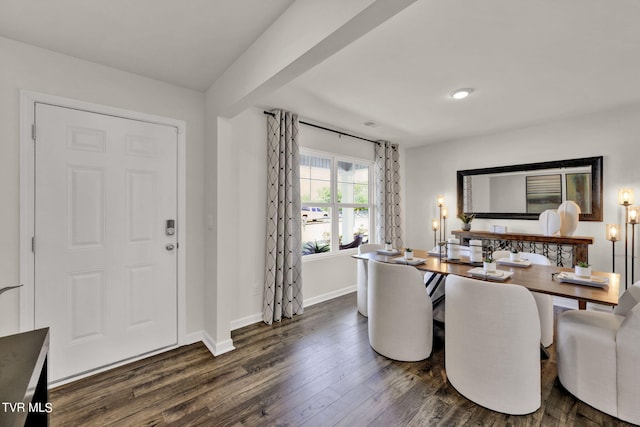 dining room with beam ceiling and dark wood-type flooring