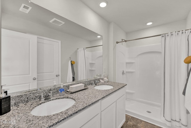 bathroom featuring walk in shower and vanity