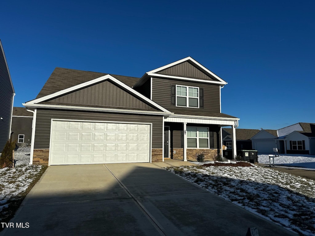 craftsman inspired home with board and batten siding, concrete driveway, an attached garage, and stone siding