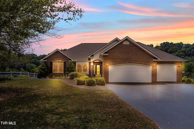 view of front of property featuring a garage and a lawn