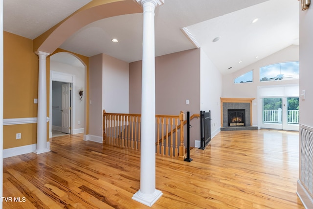 interior space featuring decorative columns, high vaulted ceiling, and light wood-type flooring