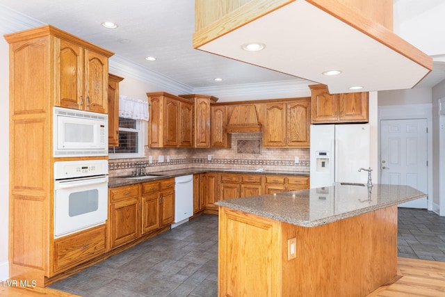 kitchen with tasteful backsplash, white appliances, sink, and a center island with sink