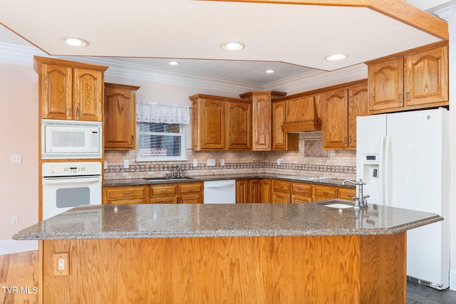 kitchen featuring crown molding, sink, white appliances, and an island with sink