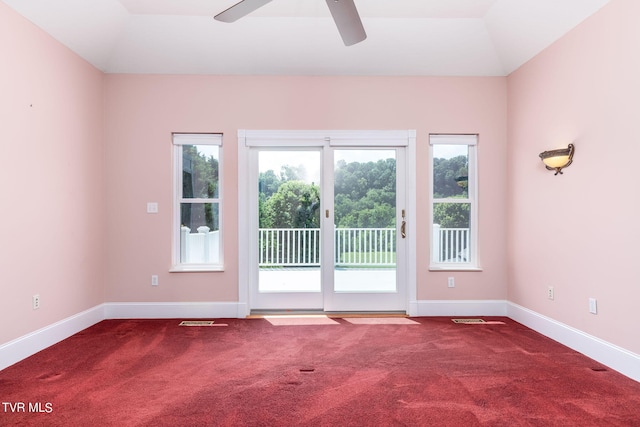 empty room featuring vaulted ceiling, a healthy amount of sunlight, and carpet floors