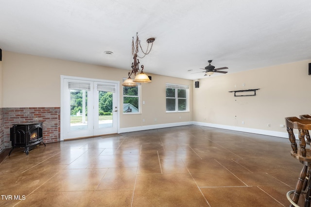 unfurnished living room featuring ceiling fan and a wood stove