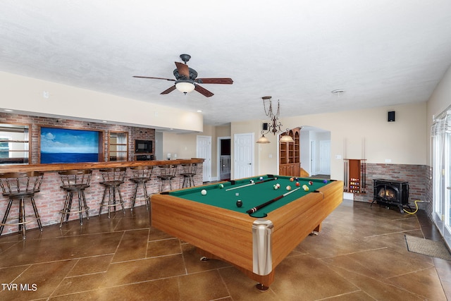 game room featuring bar, a healthy amount of sunlight, a textured ceiling, and ceiling fan