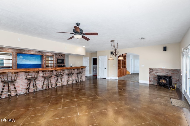 living room with ceiling fan, bar area, a textured ceiling, and a wealth of natural light