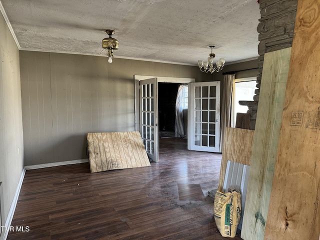 interior space featuring crown molding, dark hardwood / wood-style flooring, a chandelier, and a textured ceiling