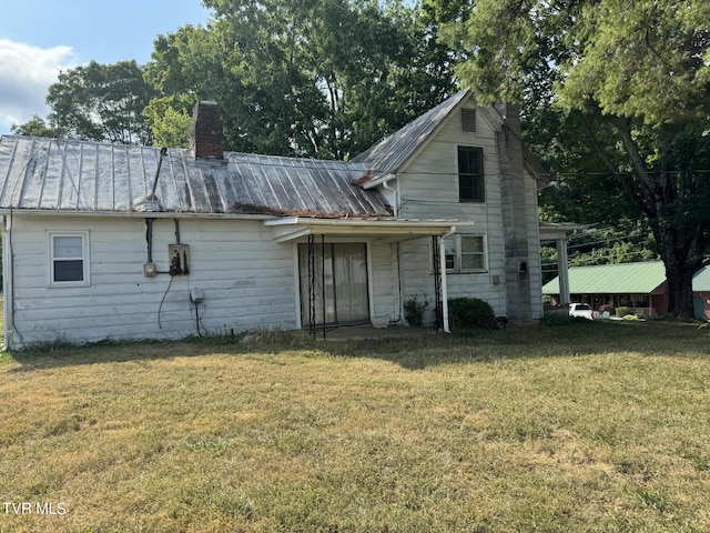 back of house featuring a lawn