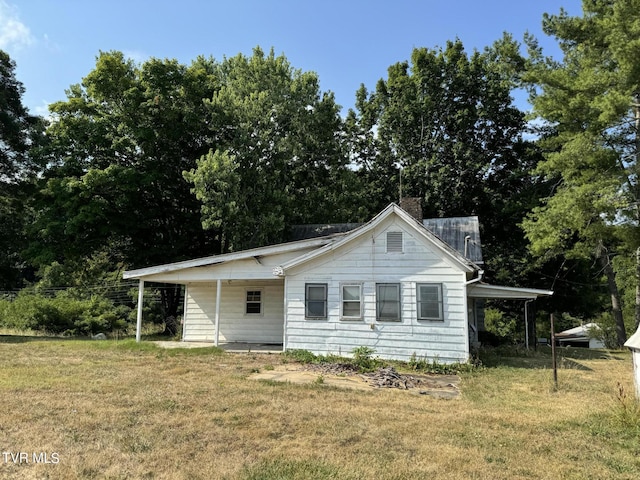 view of side of home featuring a carport and a lawn