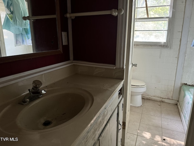 bathroom featuring vanity, toilet, tile patterned flooring, and a tub