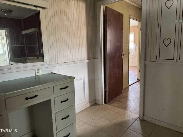 bathroom featuring tile patterned flooring and wooden walls