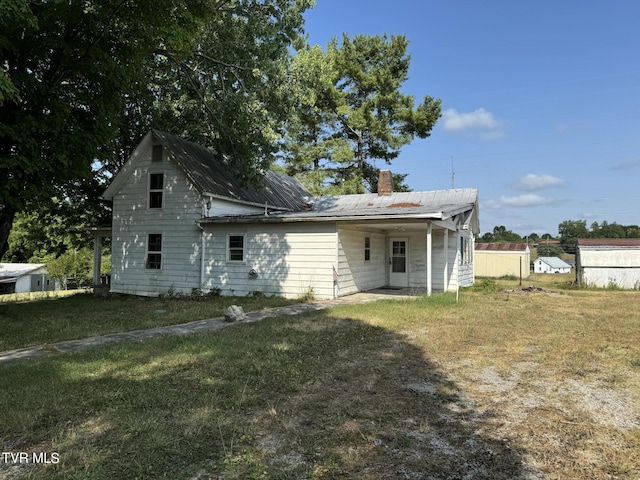 back of house featuring a lawn