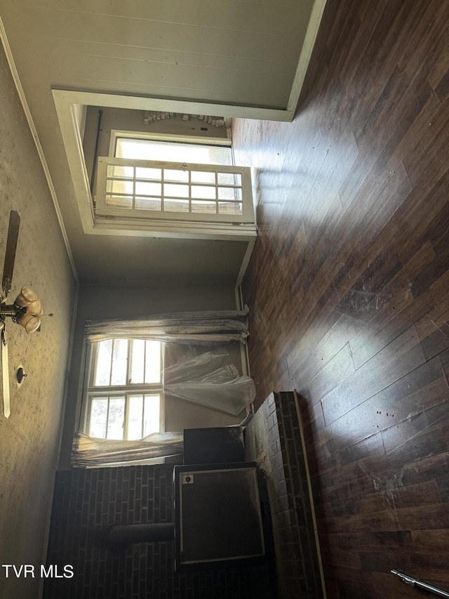 interior space featuring ornamental molding and wooden walls