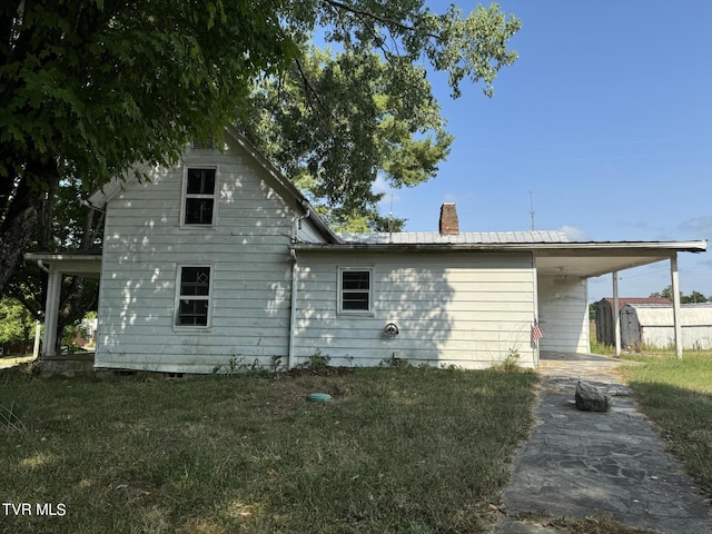 view of property exterior with a carport and a yard