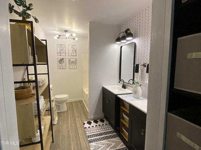 full bathroom featuring tub / shower combination, hardwood / wood-style floors, vanity, toilet, and a chandelier