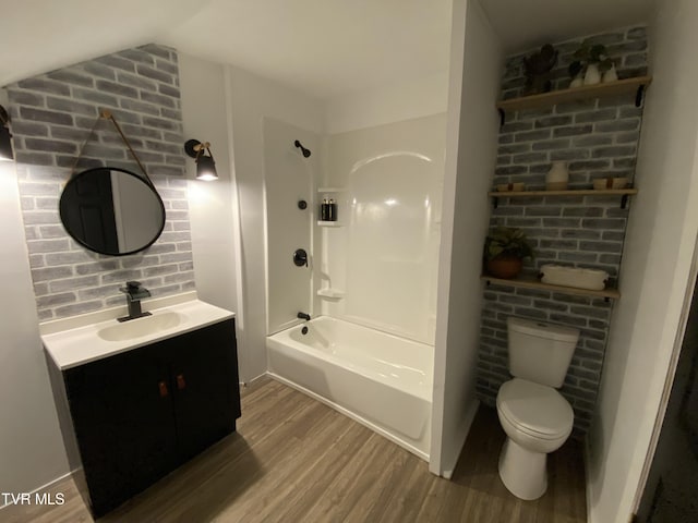 full bathroom with toilet, vanity, lofted ceiling, hardwood / wood-style floors, and shower / bathing tub combination