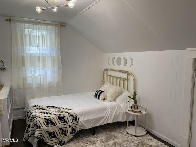 bedroom with lofted ceiling and an inviting chandelier