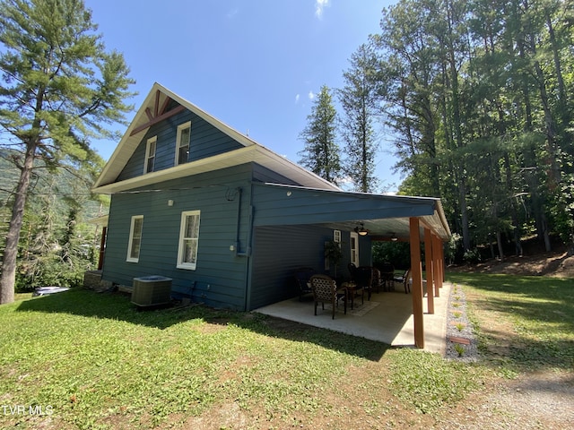 back of property with a lawn, central AC unit, and a patio area