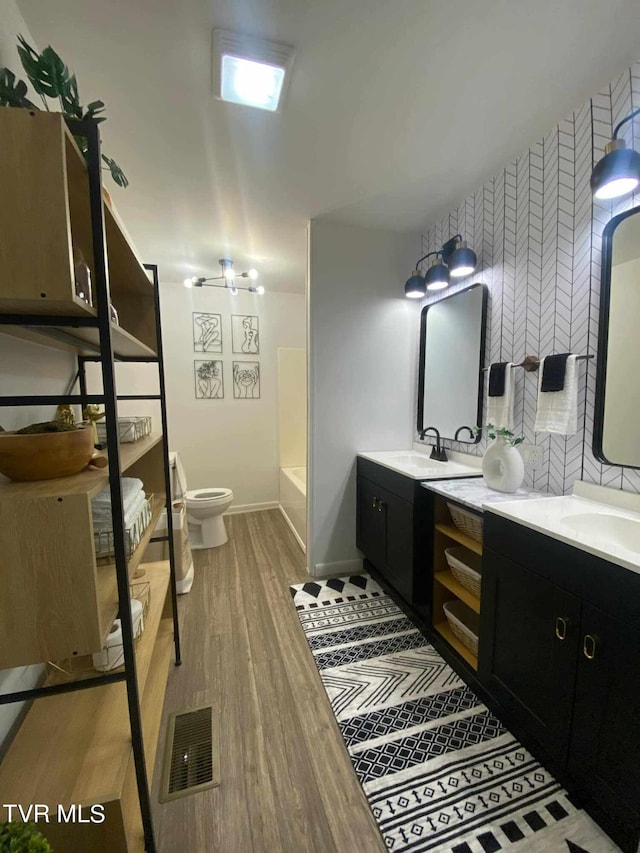 bathroom featuring toilet, hardwood / wood-style flooring, and vanity