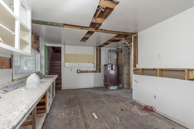 kitchen featuring heating unit, light stone counters, and sink