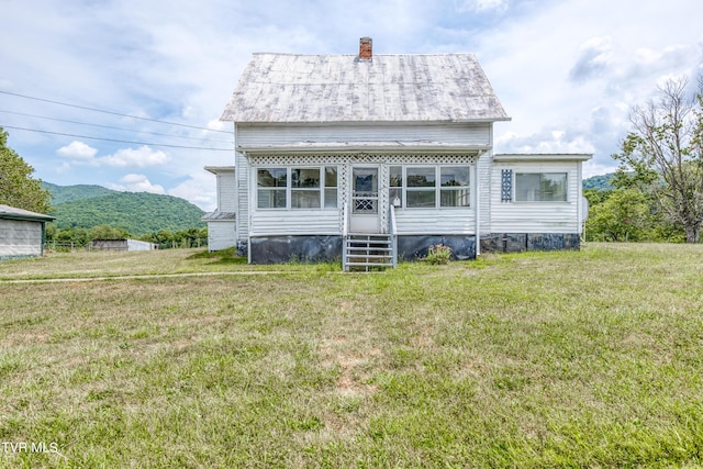 view of front facade with a front lawn and a mountain view